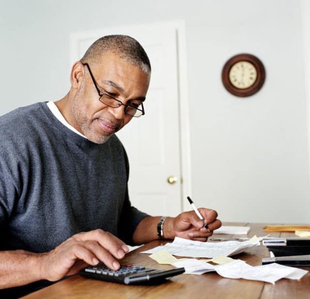 Mature man doing finances in home office
