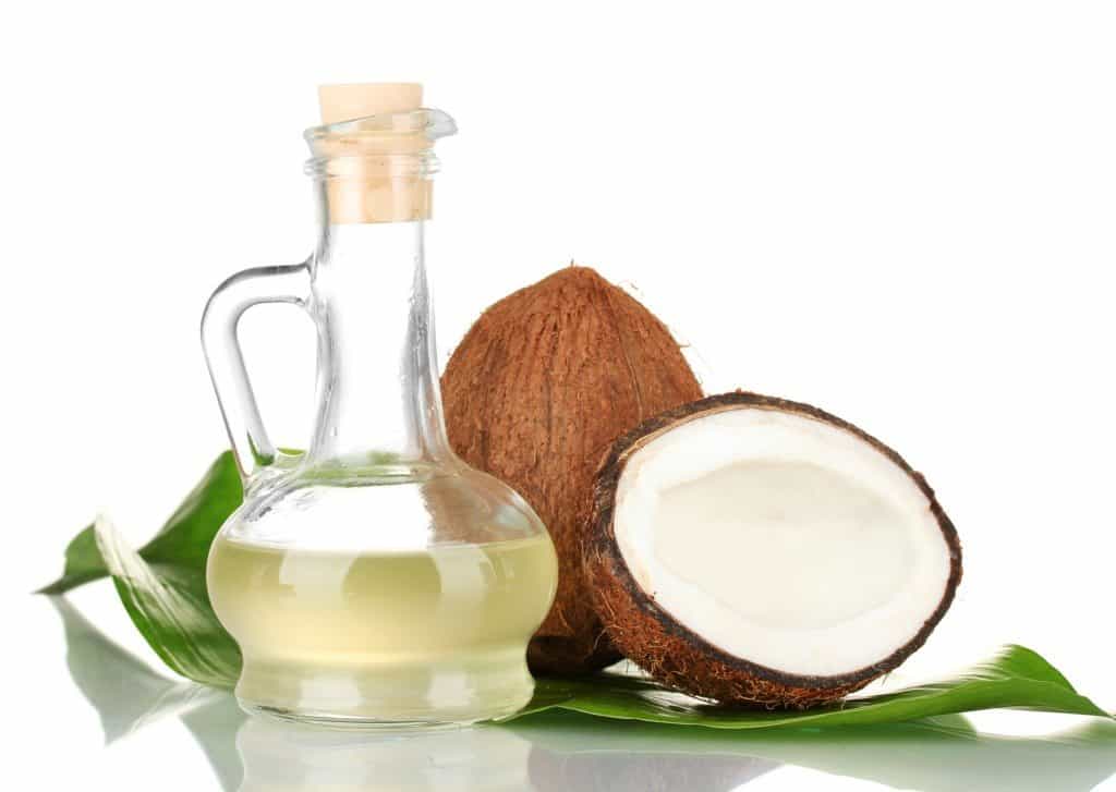 decanter with coconut oil and coconuts isolated on whitecoconut oil in bottles with coconuts on white backgroundcoconut oil in bottles with coconuts on green background